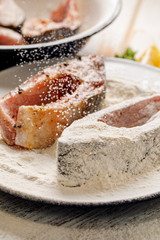 Fresh, raw carp fish slices seasoned sea salt and spices, breaded in flour and breadcrumbs. Preparing fish for frying