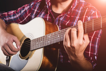 GUITARIST PLAYS ON THE ACOUSTIC GUITAR ON THE STAGE
