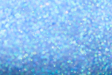 Blurred shiny blue background with sparkling lights.