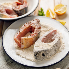Fresh, raw carp fish slices seasoned sea salt and spices, breaded in flour and breadcrumbs. Preparing fish for frying