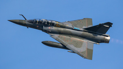 Naklejka na ściany i meble French military green double seater fighter jet aircraft in flight with a blue sky