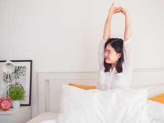 asian woman stretching in bed after wake up