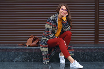 Portrait of young woman posing in street of a European city