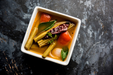 Drumstick Curry or Shevga sheng bhaji or south indian Sambar, served in a bowl over moody...