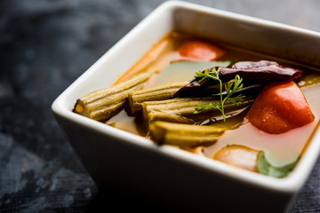 Drumstick Curry or Shevga sheng bhaji or south indian Sambar, served in a bowl over moody background. Selective focus