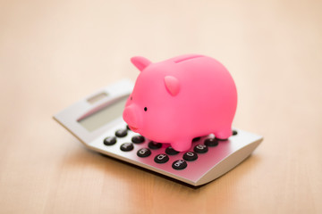 Piggy bank on calculator. Saving, accounting or banking concept.