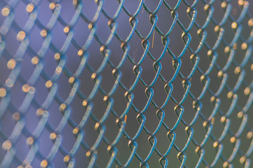 Diamond-shaped steel mesh fence close-up background