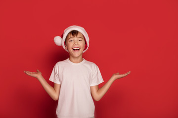Happy boy posing in Santa Claus hat.