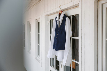 groom's suit hanging on a white wall