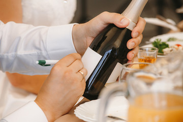 groom signs a bottle of champagne