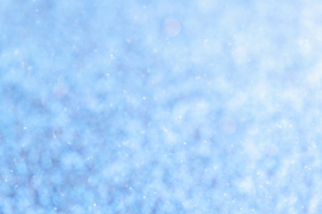 Blurred shiny blue background with sparkling lights.