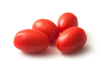 closeup of mini organic tomatoes roma on white background
