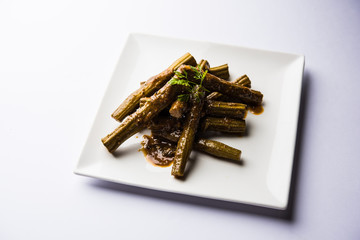 Drumstick masala or Shevga sheng sukhi sabji, served in a plate over moody background. Selective focus