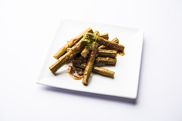 Drumstick masala or Shevga sheng sukhi sabji, served in a plate over moody background. Selective...