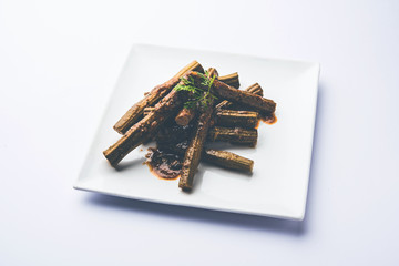 Drumstick masala or Shevga sheng sukhi sabji, served in a plate over moody background. Selective focus