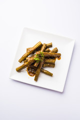 Drumstick masala or Shevga sheng sukhi sabji, served in a plate over moody background. Selective focus
