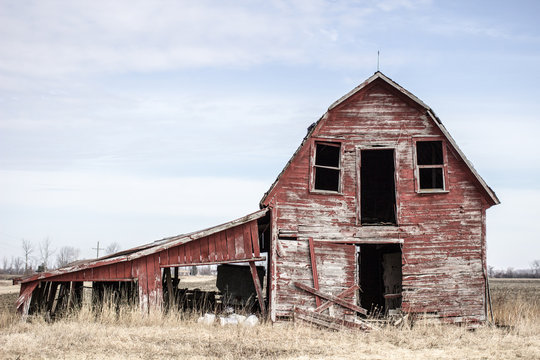 Abandoned Midwest Barn. Weathered and worn red barn on an abandoned farm in the American Midwest.