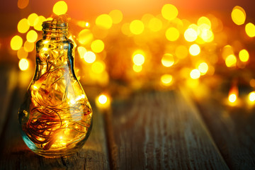 Merry Christmas and happy New year. Christmas garland in a glass jar on a wooden table. Selective focus.