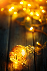 Merry Christmas and happy New year. Christmas garland in a glass jar on a wooden table. Selective focus.