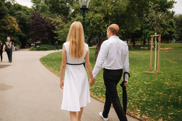 Young couple walking in the park. The have fun and rejoice. Black and white clothes