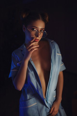 Obraz premium Sexy girl in nurse costume on dark background. Decollete model