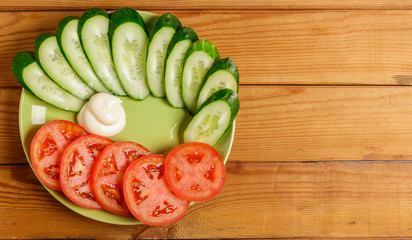 Cucumbers, tomatoes, peppers and sauce cut into pieces on a plate.