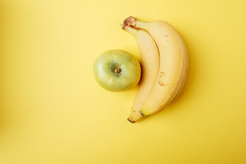 Banana apple fruit on yellow background isolated