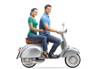 Young male and female riding on a vintage motorbike