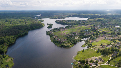 Aerial view of a small river with trees and houses on the shore
