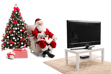 Santa Claus sitting in an armchair, holding a remote controller and watching TV © Ljupco Smokovski