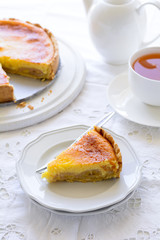 Delicious banana cake (cheesecake) with tea cup on white table. Teatime concept. Copy space