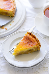Delicious banana cake (cheesecake) with tea cup on white table. Teatime concept. Copy space