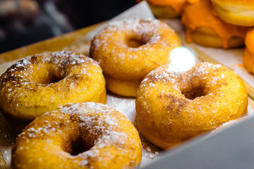 Donuts and rings. Hot pastries lie on the shelf in the cafe. Buns and bagels in the store.