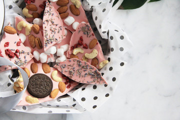 Pieces of chocolate with nuts, berries, lavender, marshmallow, cookies