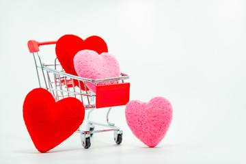 Red and Pink hearts in mini shopping cart falling on the background for valentines day, Top view and copy space.