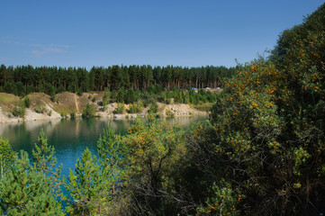 Fototapeta na wymiar mountain lake in the summer at noon with vacationers and swimming tourists