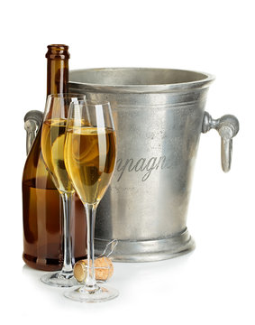 Champagne bottle with ice bucket and glasses of champagne isolated.