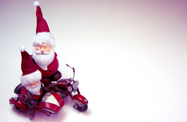 Two Santa Clauses on the red motorcycle are going to the Christmas party. Christmas and New Year holiday background concept. Copy space for text.