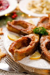 Fried carp fish slices on a white plate, close up. Traditional christmas eve dish. Polish Christmas food