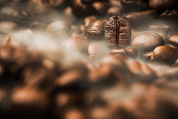 Close up pile of Coffee beans roasting with smoke