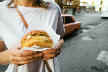 Woman hands holding a hamburger. Street food.