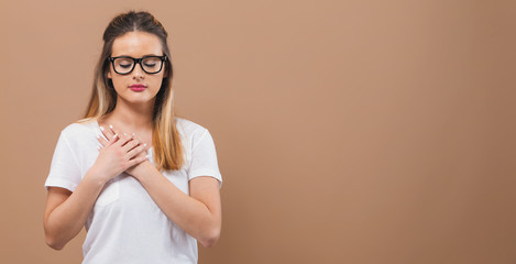 Woman with heartfelt expression on a brown background