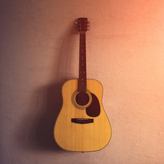 Fototapeta na wymiar old acoustic guitar on a sandy texture. sunlight.