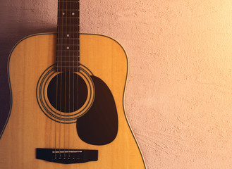 Obraz premium old acoustic guitar on a sandy texture. sunlight.