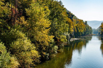 The autumn landscape with the “Cockerel” rock is reflected in the mountain river Psekups. Sunny day in the resort area of Goryachiy Klyuch. Krasnodar region. Excellent natural background for any idea.