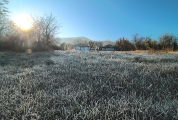 frost on the grass plain in front of the mountains