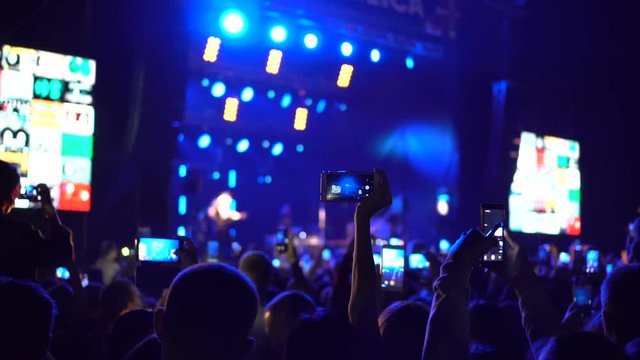 People taking photos or recording video with their smart phones at music concert
