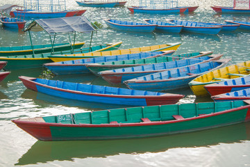 Fototapeta na wymiar Old blue red yellow green wooden boats on the water. colorful boats without people