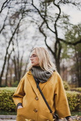 Cute blonde is walking in autumn park