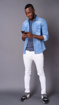 Young handsome African man with short hair against gray backgrou